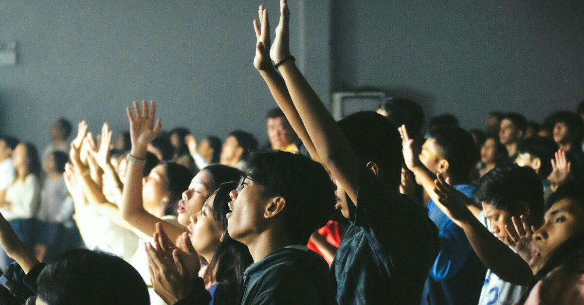Comunidad con manos alzadas celebrando la presencia de Dios